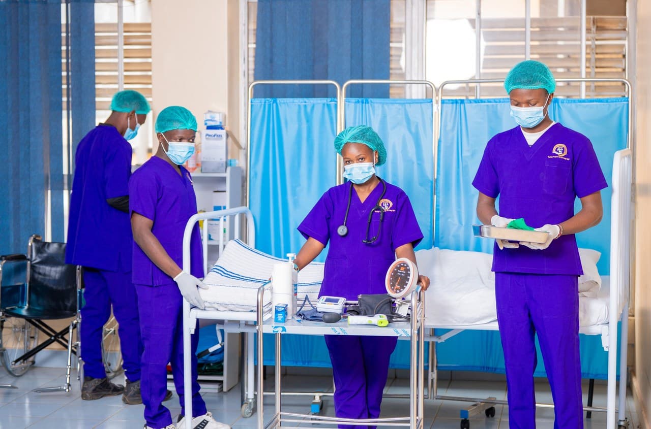 THM students in purple scrubs preparing vitals equipment in the skills lab