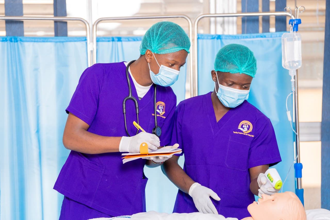THM students taking vitals on a training mannequin